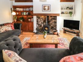 A living room with a fireplace and bookshelf at Englewood Cottage in Hexham