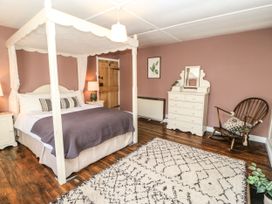 A bedroom with a canopy bed and dresser at Englewood Cottage in Hexham