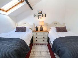 A bedroom with two single beds and a drawer unit at Englewood Cottage Hexham