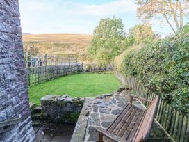 A garden with a wooden bench and stone pathway at Englewood Cottage in Hexham