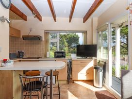 A kitchen with appliances and seating at Flat 1 Lee Cliff Park Dawlish Warren