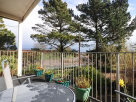 A balcony with a table and chairs and plants at Flat 1 Lee Cliff Park in Dawlish Warren