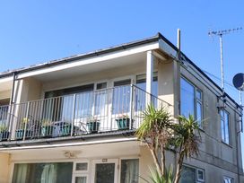 A balcony with potted plants and satellite dish at Flat 1 Lee Cliff Park Dawlish Warren