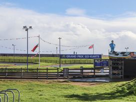 An outdoor go-kart track with flags and a ticket booth at Grand Prix Go-Karts Dawlish Warren