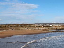 A beach scene with water, sand, and steps at Flat 1 Lee Cliff Park Dawlish Warren