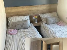 A bedroom with two beds and a wardrobe at 52 Juniper Close Exmouth