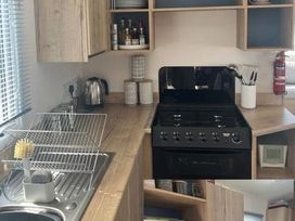 A kitchen with an oven and shelves at 52 Juniper Close in Exmouth