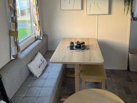 A dining area with bench seating and a table at 52 Juniper Close Exmouth
