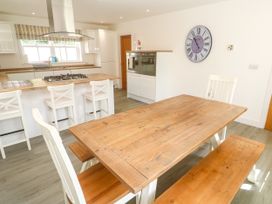 A kitchen with a dining table and stove at Rosevale Villa in St Ives