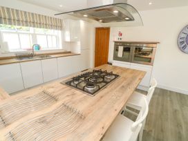 A kitchen with a gas stove and wooden table at Rosevale Villa in St Ives