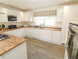 A kitchen with modern appliances and wooden countertop at Rosevale Villa, St Ives