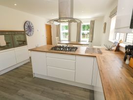 A kitchen with a gas cooker and dining table at Rosevale Villa in St Ives