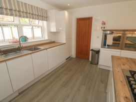 A kitchen with appliances and cabinetry at Rosevale Villa in St Ives