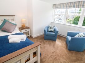 A bedroom with a bed and chairs at Rosevale Villa St Ives