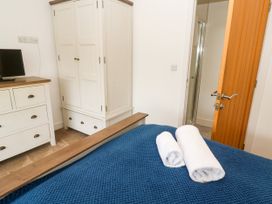 A bedroom with a bed towels and wardrobe at Rosevale Villa St Ives
