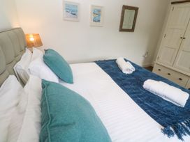 A bedroom with a bed and decorative pillows at Rosevale Villa in St Ives