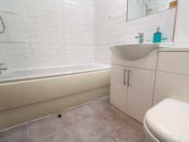 A bathroom featuring a bath tub, sink, mirror, and toilet at Rosevale Villa St Ives