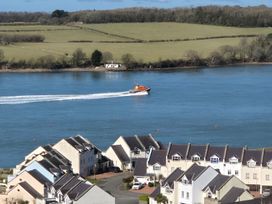 A view of a boat on a river near residential buildings at Bryn Y Felin in Y Felinheli