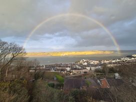 A view of houses and a river with a rainbow at Bryn Y Felin in Y Felinheli