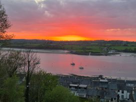 A sunset over a river with boats and houses at Bryn Y Felin in Y Felinheli
