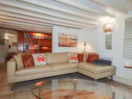 A living room with a sofa and bookshelf at Plenteth in Truro