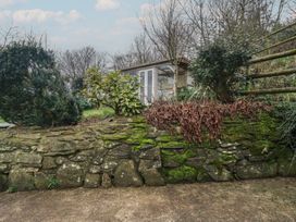 A garden with a stone wall and a shed at Plenteth in Truro