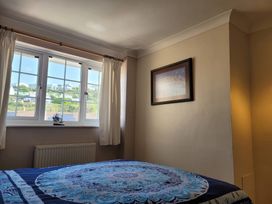 A bedroom featuring a bed, window, curtains, picture and radiator at 16 Forth An Nance Portreath