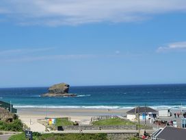A beach with a rock formation and the sea at 16 Forth An Nance in Portreath