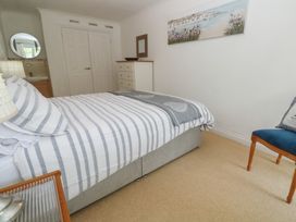A bedroom with a bed and a chair at 16 Forth An Nance in Portreath