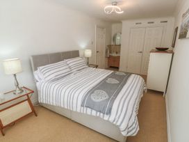 A bedroom with a bed and a wardrobe at 16 Forth An Nance in Portreath