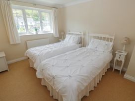 A bedroom with two single beds and a bedside table at 16 Forth An Nance in Portreath