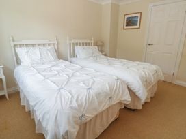A bedroom with two single beds and a bedside table at 16 Forth An Nance in Portreath