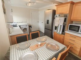 A kitchen with appliances and a dining table at 16 Forth An Nance in Portreath