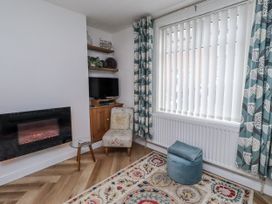 A living room with a fireplace and a TV at 55 Meldon terrace in Newbiggin-by-the-Sea