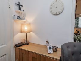 A hallway with a lamp and clock on a wooden cabinet at 55 Meldon terrace Newbiggin-by-the-Sea