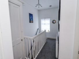 A hallway with a staircase and a window at 55 Meldon terrace Newbiggin-by-the-Sea