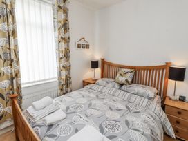 A bedroom with a wooden bed and nightstands at 55 Meldon terrace Newbiggin-by-the-Sea