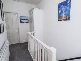 A hallway with a door and wall art at 55 Meldon terrace in Newbiggin-by-the-Sea