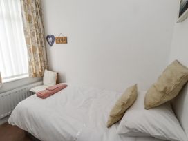A bedroom with a bed and chair at 55 Meldon terrace Newbiggin-by-the-Sea