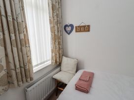 A bedroom with a chair and a towel on the bed at 55 Meldon terrace in Newbiggin-by-the-Sea