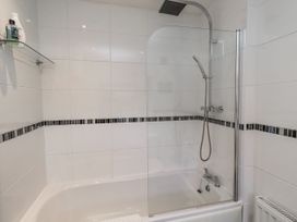 A bathroom featuring a bathtub with a shower and shelf at 55 Meldon terrace in Newbiggin-by-the-Sea