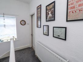 A hallway with framed posters and a window at 55 Meldon terrace Newbiggin-by-the-Sea