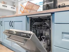A kitchen with a dishwasher and dish rack at Bay Tree Cottage Heacham