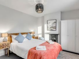 A bedroom with a bed, nightstands, and a wardrobe at Bay Tree Cottage Heacham