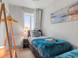 A bedroom with two single beds and a coat rack at Bay Tree Cottage in Heacham