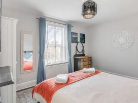A bedroom with a bed and dresser at Bay Tree Cottage in Heacham