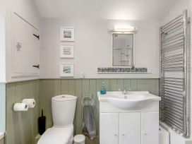 A bathroom with a toilet, sink, and towel radiator at Bay Tree Cottage in Heacham
