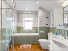 A bathroom with a bathtub, shower, sink, and toilet at Bay Tree Cottage in Heacham