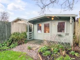 A garden shed with doors and windows at Bay Tree Cottage in Heacham