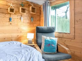 A bedroom with a chair and decorative items at Bay Tree Cottage in Heacham